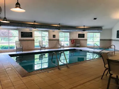 a large swimming pool with chairs and a table at Country Inn & Suites by Radisson, Queensbury - Lake George , NY in Lake George