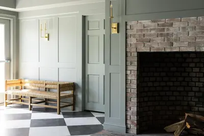 a living room with a brick fireplace and a bench at The Litchfield Inn in Litchfield