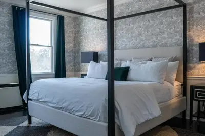 a bedroom with a large bed with white pillows at The Litchfield Inn in Litchfield