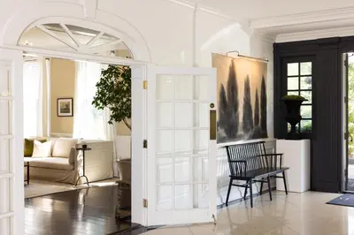 a living room with a door and a chair at The Litchfield Inn in Litchfield
