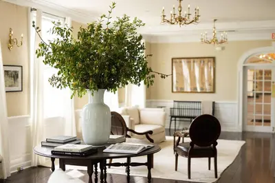 a living room with a table with a vase on it at The Litchfield Inn in Litchfield