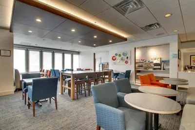 a waiting room with tables and chairs and a cafeteria at Holiday Inn Express Poughkeepsie by IHG in Poughkeepsie