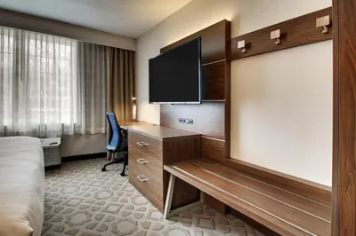 a hotel room with a bed and a flat screen tv at Holiday Inn Express Poughkeepsie by IHG in Poughkeepsie