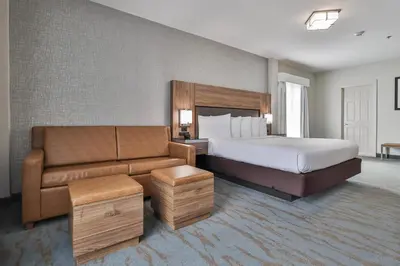 a hotel room with a bed and a couch at The Penn Stroud, Stroudsburg - Poconos, an Ascend Collection Hotel in Stroudsburg