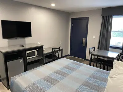 a hotel room with a bed and a flat screen tv at Golden Hill Inn-Danbury in Danbury