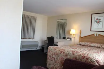 a hotel room with a bed and a desk and a tub at Elm Motel in Westfield