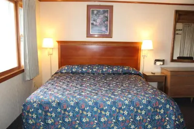 a hotel room with a bed and two lamps at Elm Motel in Westfield