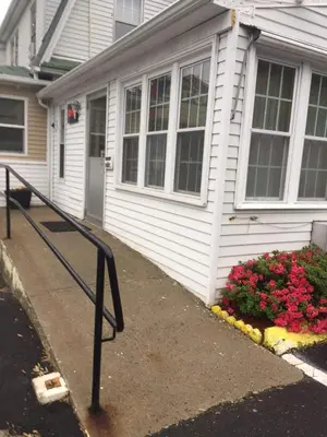 a white house with flowers in front of it at Elm Motel in Westfield