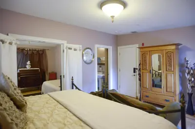 a bedroom with a bed and a dresser at Naomi's Inn Bed & Breakfast in Springfield