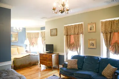 a living room with a couch and a bed at Naomi's Inn Bed & Breakfast in Springfield