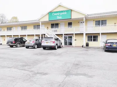 a car parking lot in front of a hotel at Countryside Inn Richmondville in Richmondville