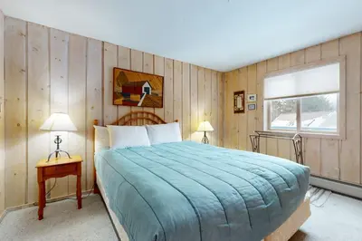 a bedroom with a large bed and a window at West Dover Getaway in West Dover