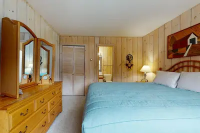 a bedroom with a bed and a dresser and a mirror at West Dover Getaway in West Dover