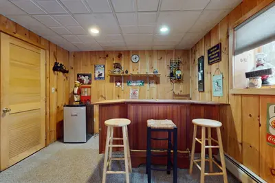 a bar with two stools and a refrigerator at West Dover Getaway in West Dover
