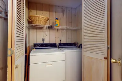 a washer and dryer in a small kitchen with wooden walls at West Dover Getaway in West Dover