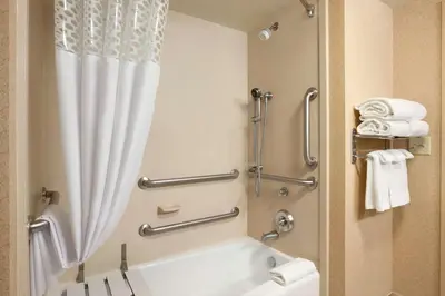 a bathroom with a tub and a shower with a shower curtain at Hampton Inn & Suites East Hartford in East Hartford