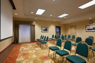a conference room with chairs and a projection screen at Hampton Inn & Suites East Hartford in East Hartford