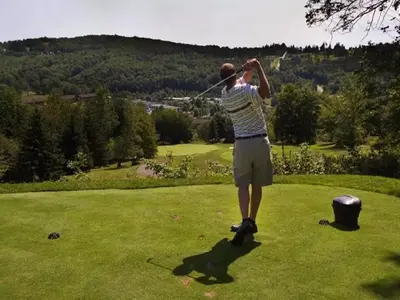 a man swinging a golf club on a golf course at Villa Roma Resort and Conference Center in Callicoon