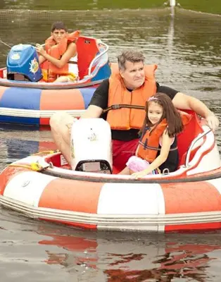 a man and a little girl in an inflatable boat in the water at Villa Roma Resort and Conference Center in Callicoon