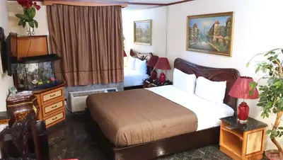 a hotel room with a bed and a bedroom with at Paris Suites Hotel in Queens