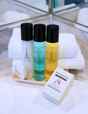 a group of three bottles of soap and towels at Paris Suites Hotel in Queens