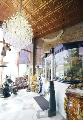 a living room with a chandelier and a fish tank at Paris Suites Hotel in Queens