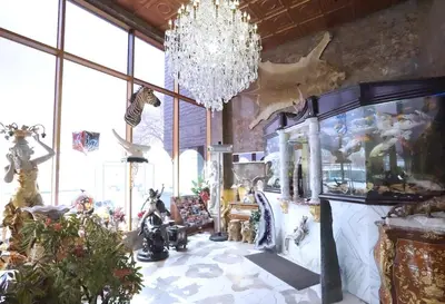 a living room with a chandelier and a room filled with animals at Paris Suites Hotel in Queens