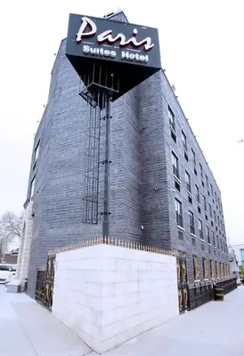 a building with a sign on the side of it at Paris Suites Hotel in Queens