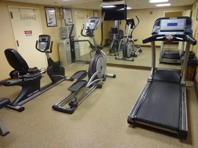a gym with several exercise bikes and a treadmill at Sheridan Hotel in Bronx