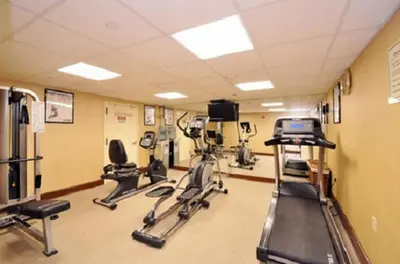 a gym with treadmills and elliptical machines at Sheridan Hotel in Bronx