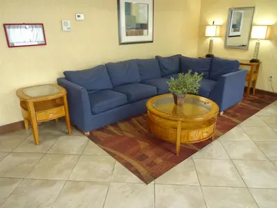 a living room with a blue couch and a coffee table at Sheridan Hotel in Bronx