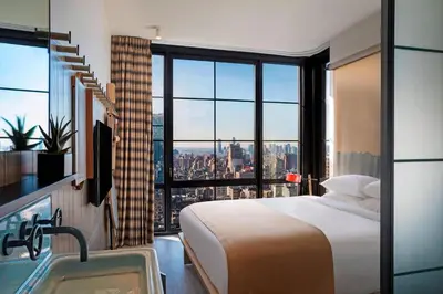 a hotel room with a bed and a view of the city at Moxy NYC Chelsea in New York