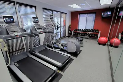 a gym with cardio equipment in a room at Hilton Garden Inn Westbury in Westbury