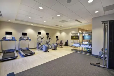 a gym with treadmills and ellipticals in a room at Home2 Suites by Hilton Queensbury Lake George in Queensbury