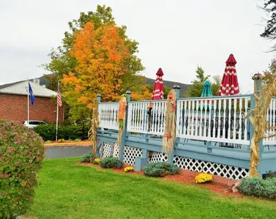 a white fence with umbrellas in a yard at Williamstown Motel in Williamstown