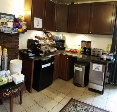 a kitchen with wooden cabinets and a black refrigerator at Williamstown Motel in Williamstown