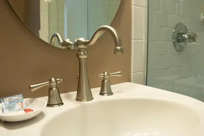 a bathroom sink with a faucet and a mirror at Inn on the Hudson in Peekskill