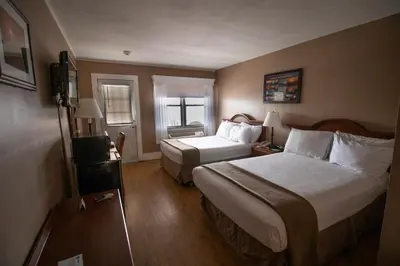 a hotel room with two beds and a television at Inn on the Hudson in Peekskill