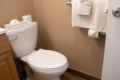 a bathroom with a white toilet and towels at Inn on the Hudson in Peekskill