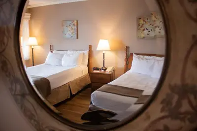 a hotel room with two beds and a mirror at Inn on the Hudson in Peekskill