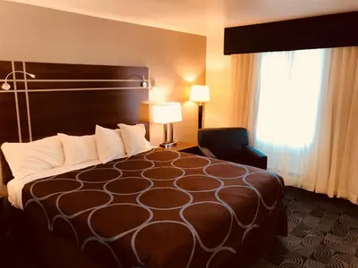 a hotel room with a bed and a chair and a window at Berkshire Inn in Pittsfield