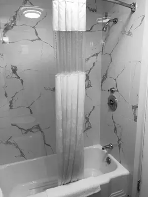 a bathroom with a shower curtain next to a tub at Berkshire Inn in Pittsfield