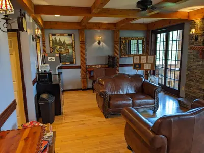a living room with leather chairs and a couch at August Lodge Cooperstown in Hartwick Seminary