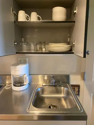 a kitchen counter with a sink and a coffee maker at August Lodge Cooperstown in Hartwick Seminary