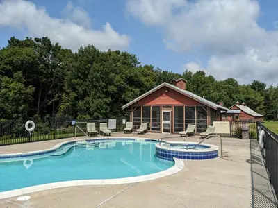 a swimming pool in front of a house at August Lodge Cooperstown in Hartwick Seminary