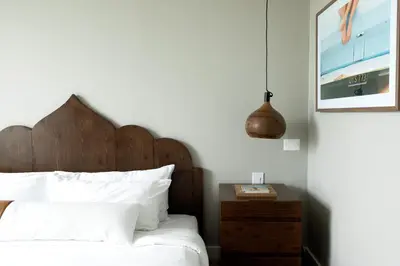 a bedroom with a bed with a wooden headboard and a table at CODA Williamsburg in Brooklyn