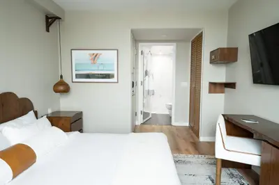 a white bedroom with a bed and a desk at CODA Williamsburg in Brooklyn