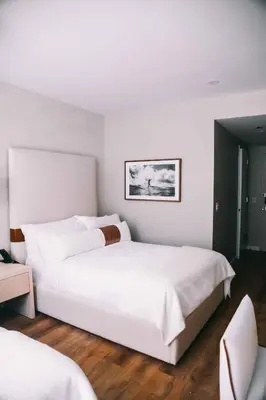 a white bedroom with a large white bed in it at CODA Williamsburg in Brooklyn