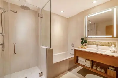 a bathroom with a shower and a sink and a tub at Concorde Hotel New York in New York