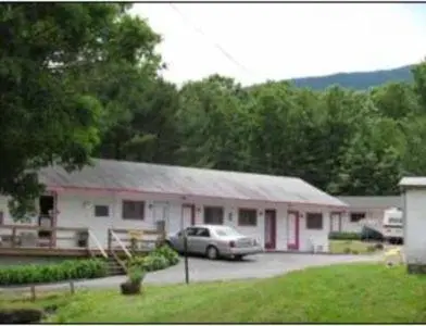 a car parked in a parking lot in front of a building at Four Seasons Motel in Catskill